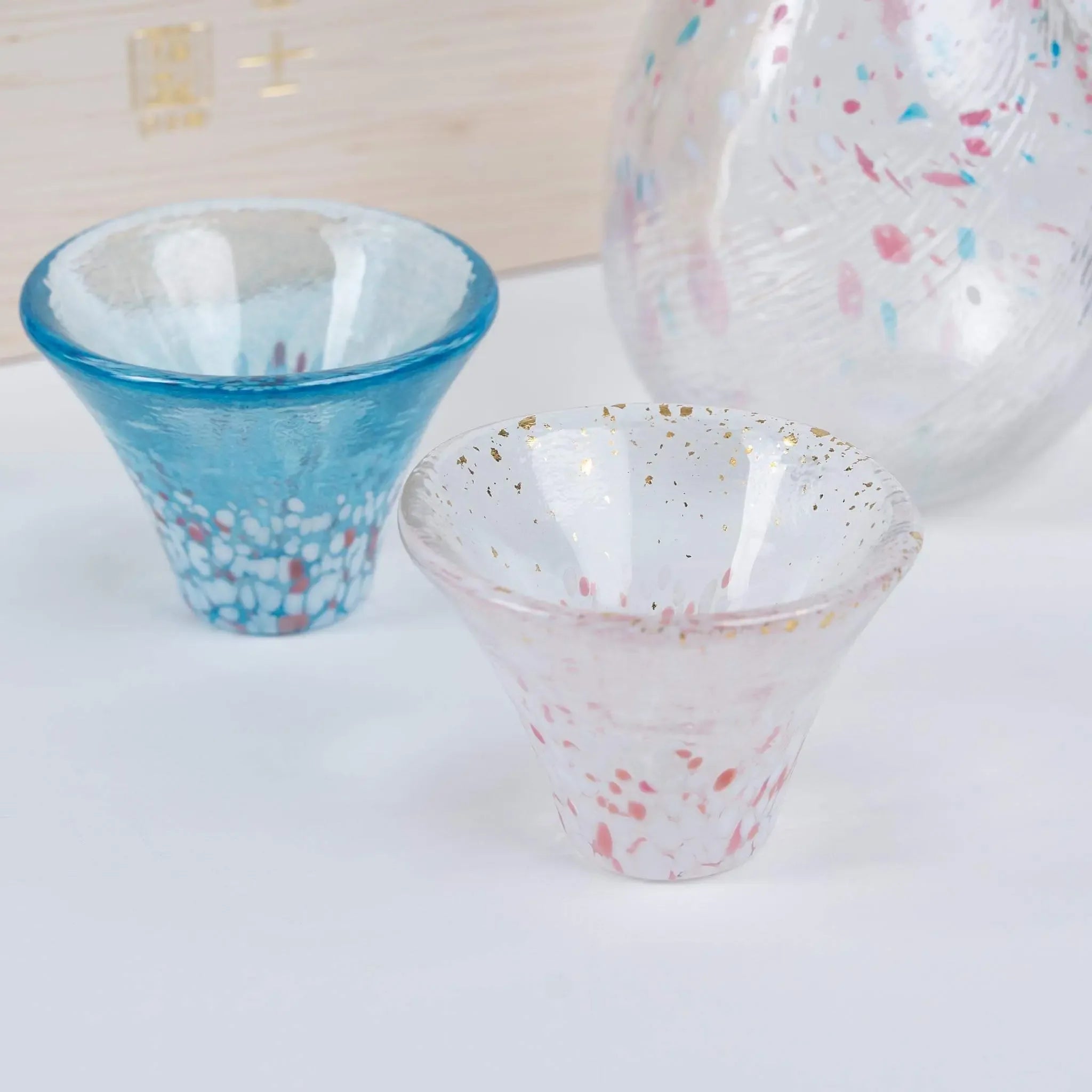 Detail of handmade Japanese sake cup showing unique glass texture inspired by cherry blossoms and Mount Fuji.