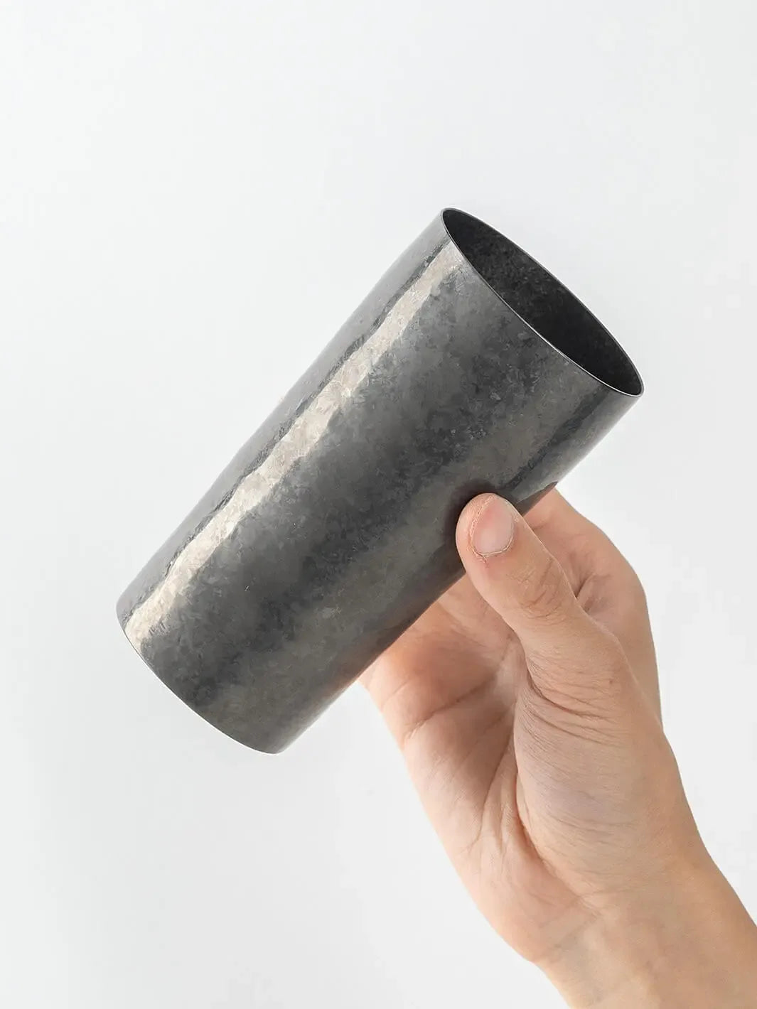 Side view of black HORIE titanium tumbler held in hand