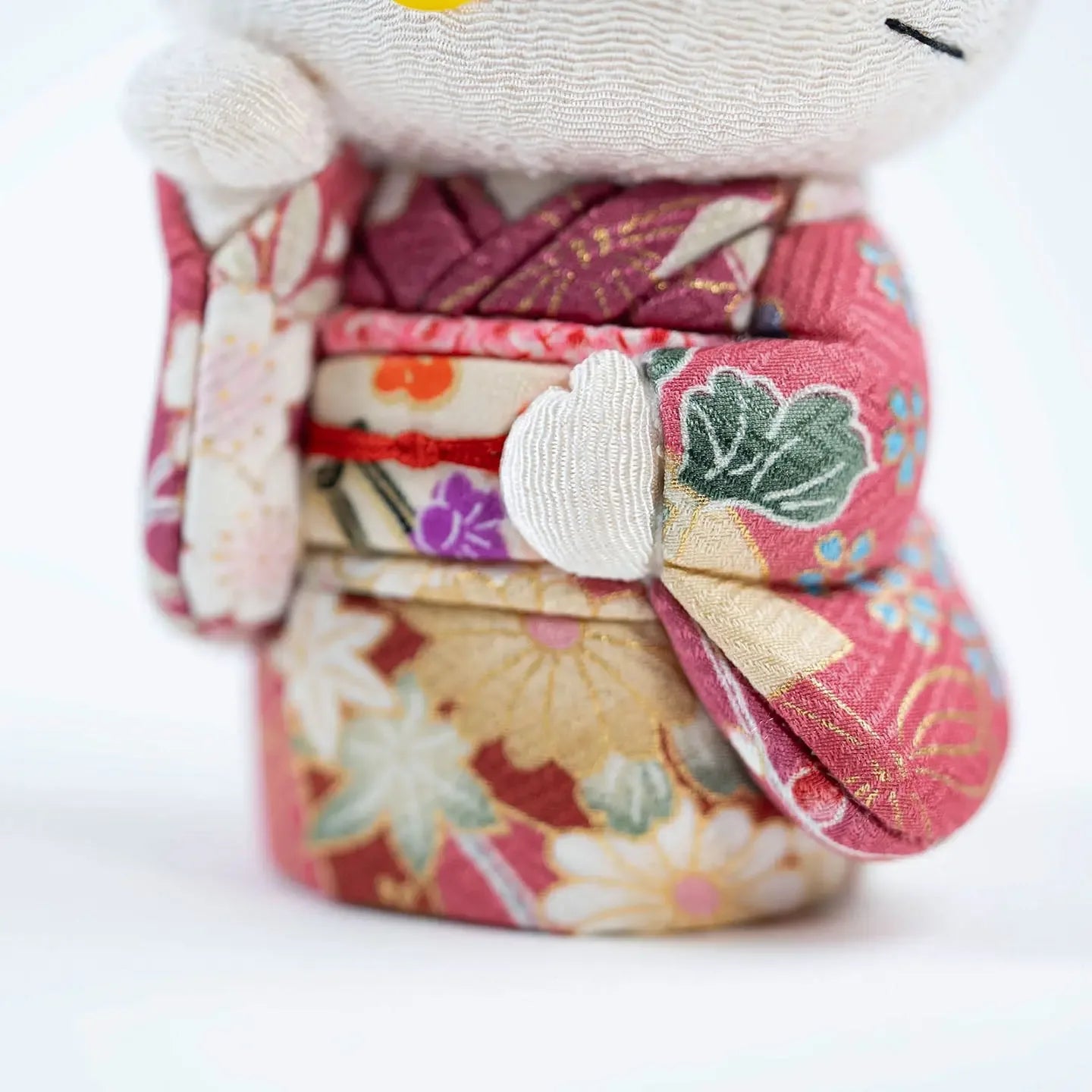 Detailed close-up of the traditional Japanese fabric used for the Hello Kitty doll's pink kimono.