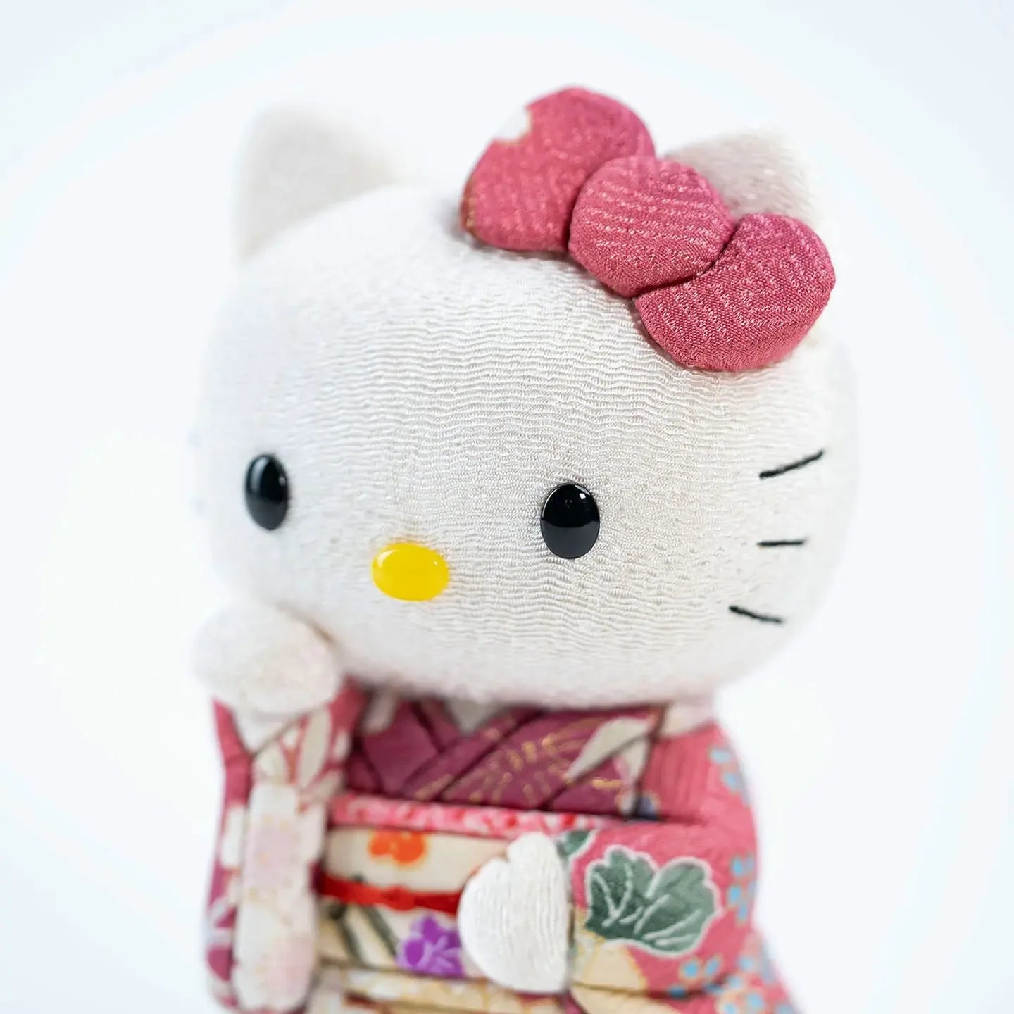 Close-up of the Hello Kitty doll's face, with her signature pink bow and sweet expression.
