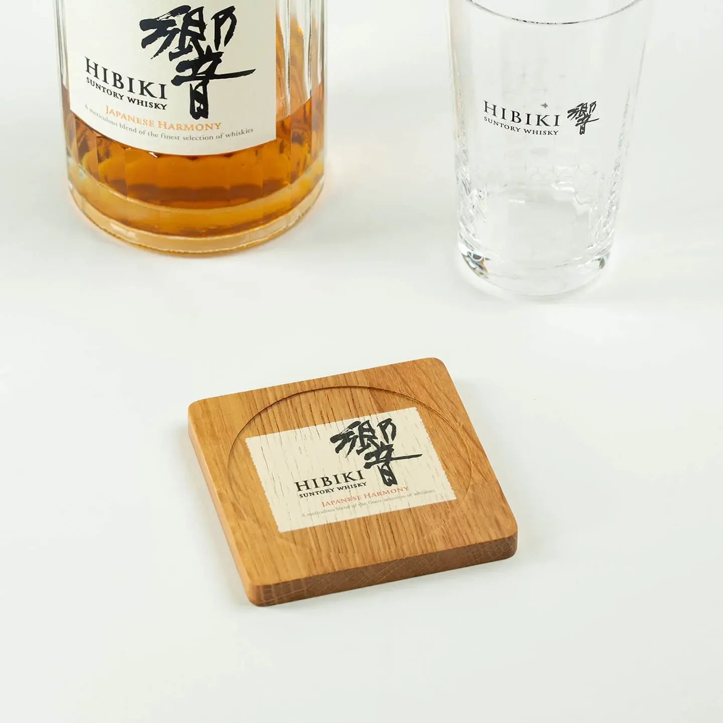 The square Hibiki cask oak coaster, featuring the classic 'Japanese Harmony' whisky label design.