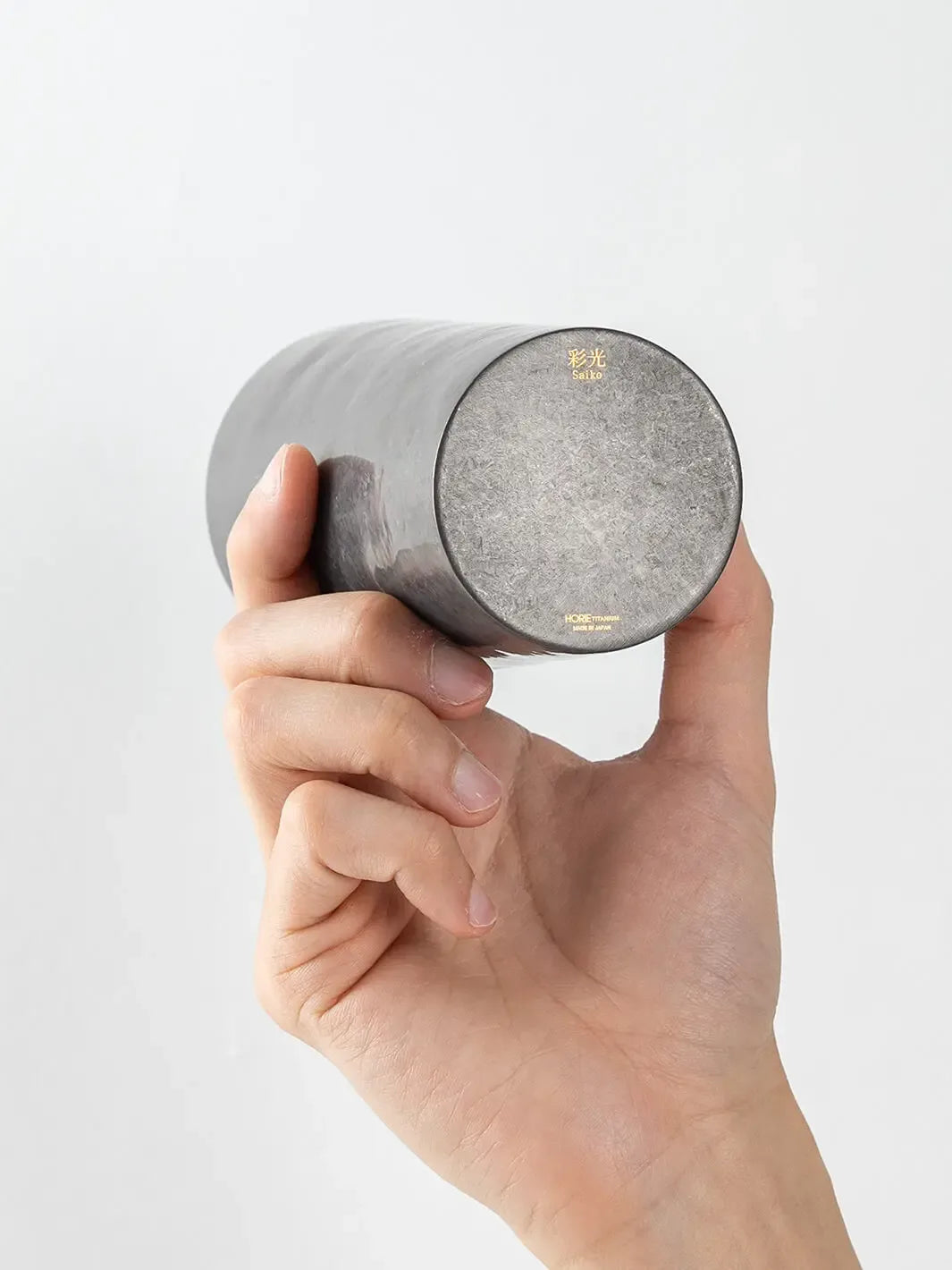 Bottom view of HORIE Saiko Series black titanium tumbler held in hand
