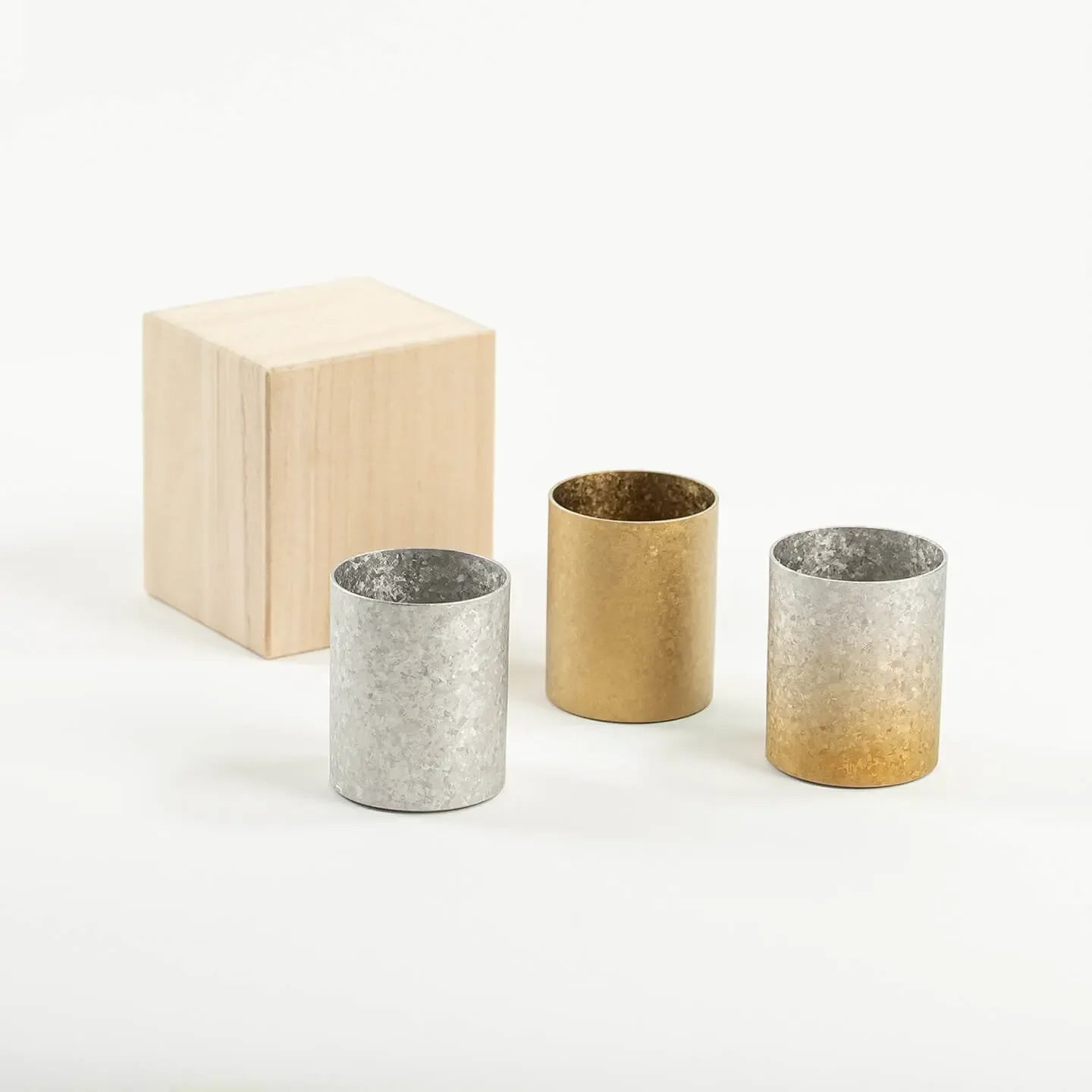 The HORIE Titanium Sake Cup shown in all three available finishes: Silver, Gold, and Gold & Silver Gradient.