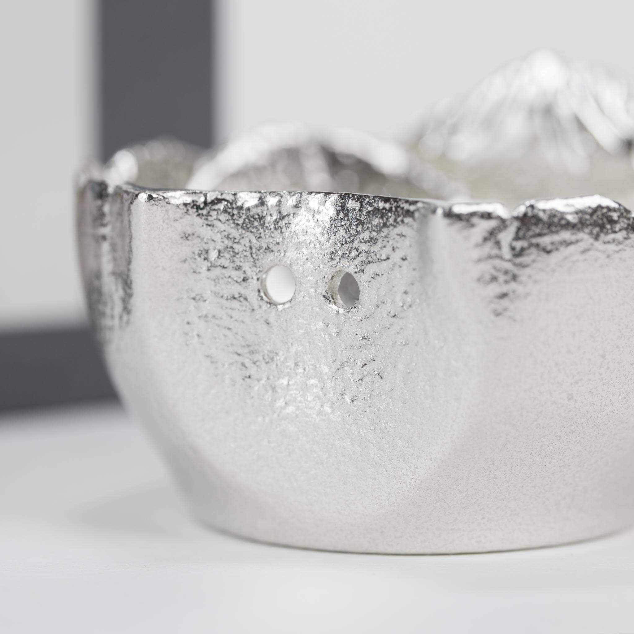 Close-up of the playful drainage hole on the Nousaku Kurobe Dam sake tumbler.